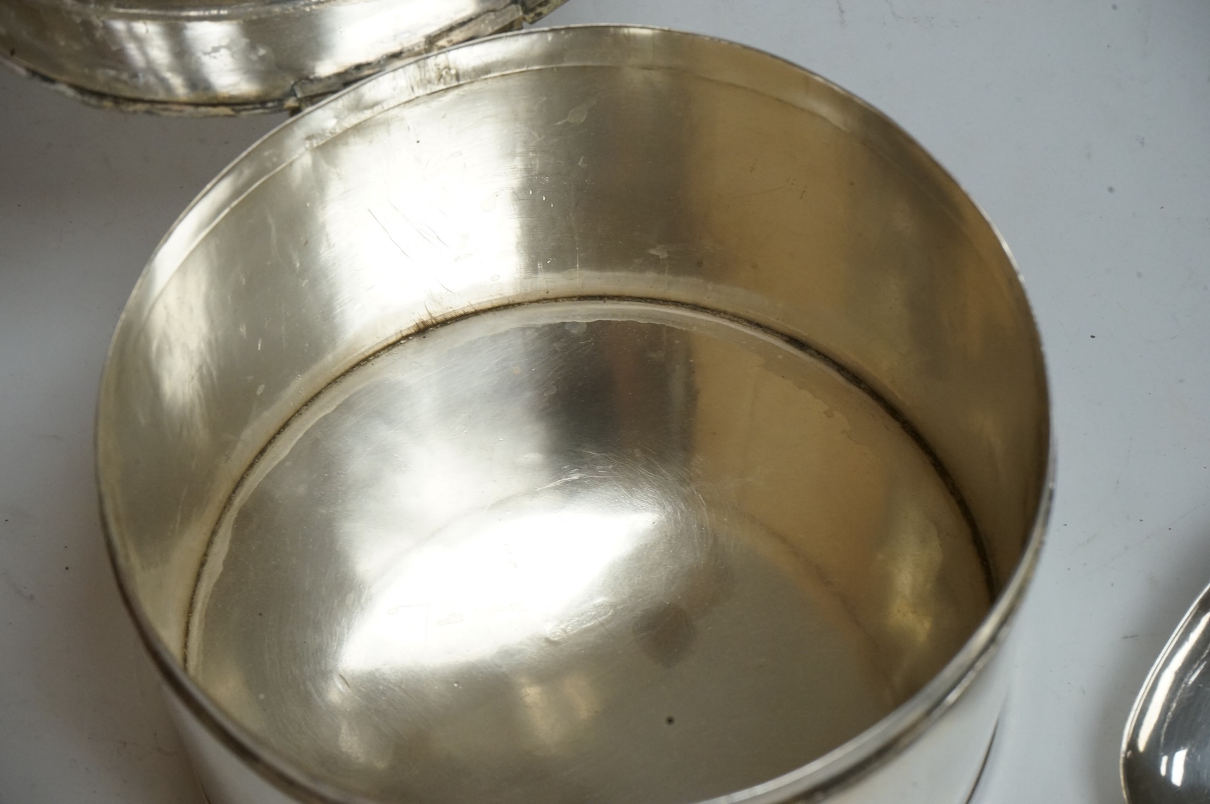 An early 19th century Dutch white metal circular biscuit box, with hinged cover and reeded bands, maker IT, retailed by Diemont, height 78mm, together with a pair of Victorian silver fiddle pattern table spoons by Willia
